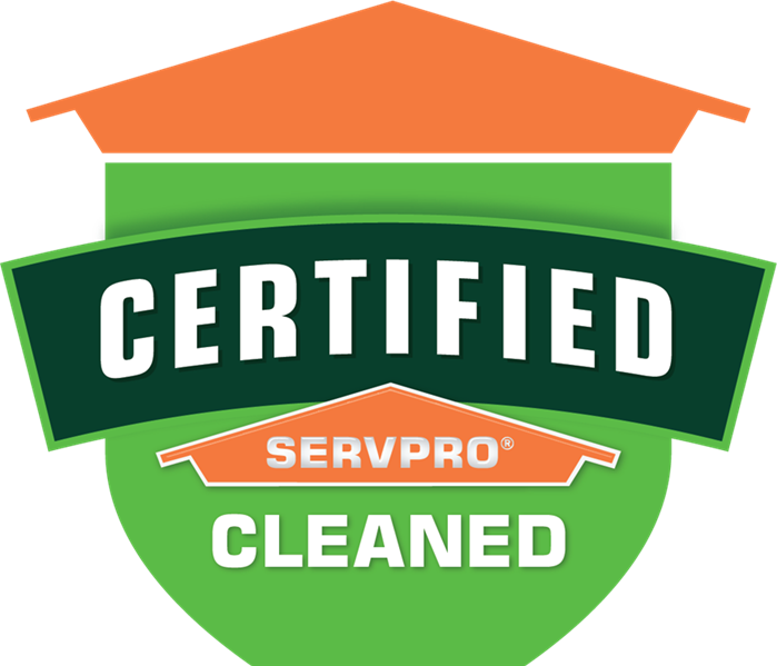 Table tent signs describing the Certified: SERVPRO Cleaned program on top of a wooden table.