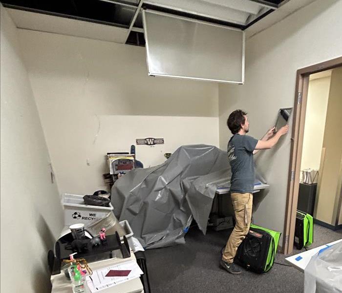 A technician working on cleaning up damage left being by a commercial water damage in an office space